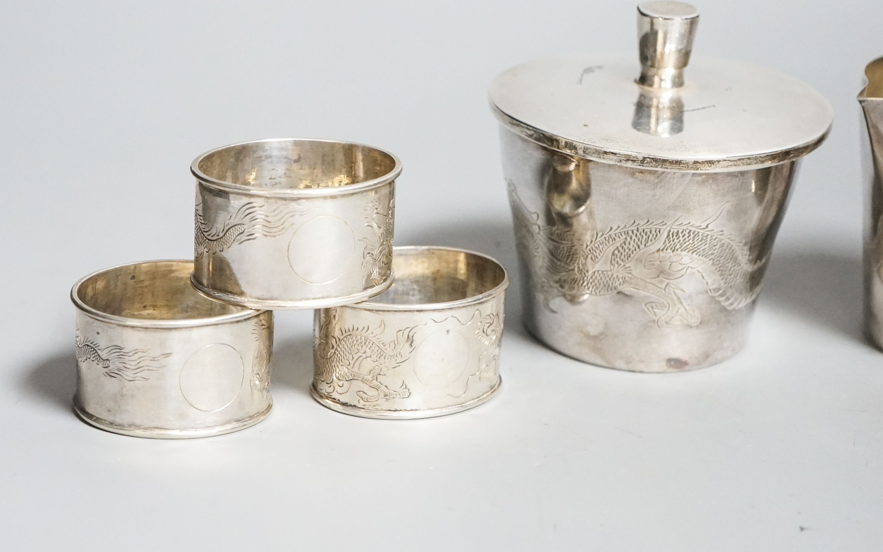 A Chinese sterling pot and cover by Kingsburg, Hong Kong, 9.4cm, a similar cream jug and six napkin rings by Wang Hing